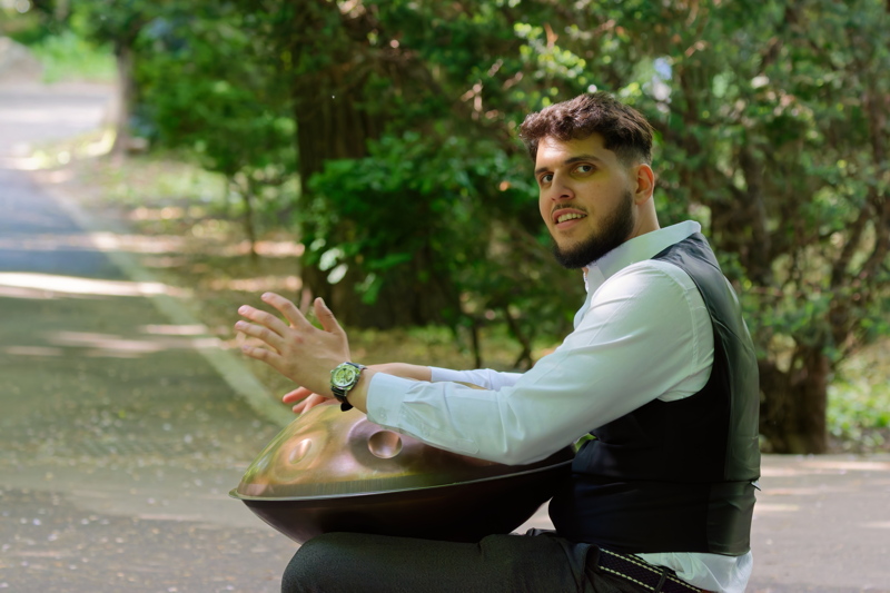 Boy playing music with a handpan